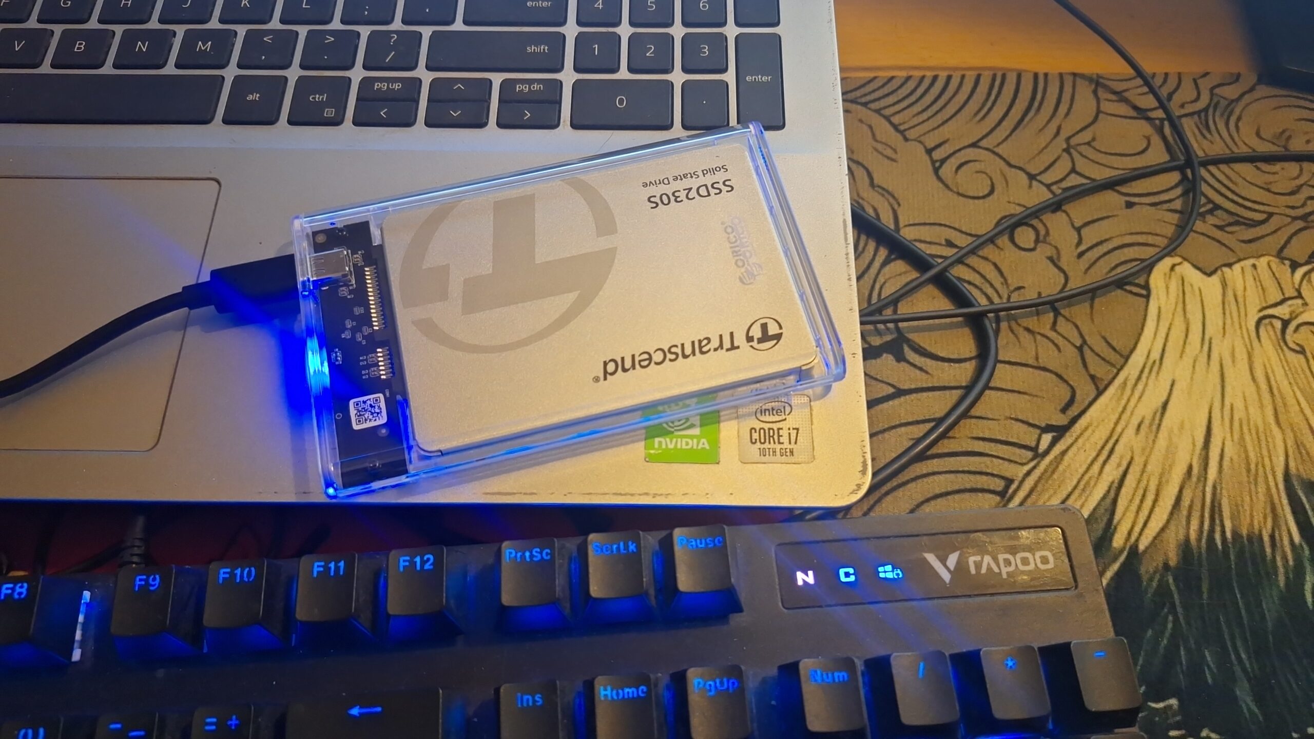 Transcend SSD230S in a clear ORICO enclosure glowing blue, connected to Ginrou